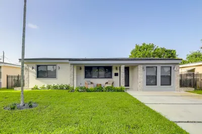 a house with a green lawn in front of it at 3 Mi to Hard Rock Stadium Retreat with Private Yard in Miramar