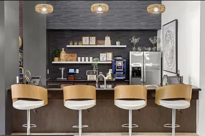 a kitchen with a bar with chairs and a refrigerator at Landing Spectacular 1BD Gym Clubhouse in Miramar