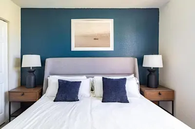 a bedroom with a white bed with blue walls and two lamps at Landing Spectacular 1BD Gym Clubhouse in Miramar
