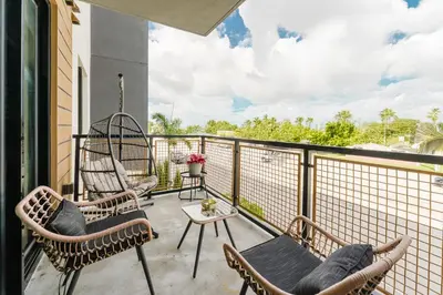 a patio with chairs and a table on a balcony at KOOSH - Boutique Aparthotel in Fort Lauderdale