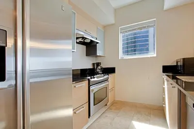 a small kitchen with a stainless steel refrigerator at Marenas Beach Resort Private Luxury Suites in Miami Beach
