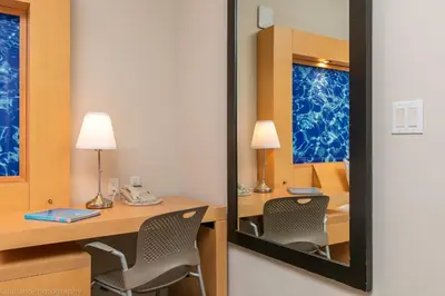 a mirror in a room with a desk and chairs at Marenas Beach Resort Private Luxury Suites in Miami Beach