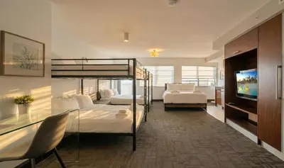 a bedroom with two bunk beds and a television at Ocean Drive Apt with Balcony & Rooftop Pool in Miami Beach