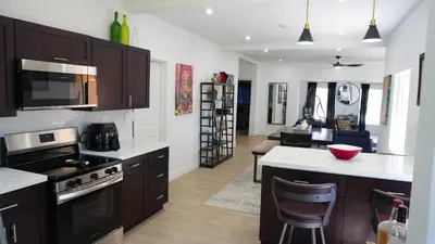 a kitchen with brown cabinets and a white counter top at Charming Historic Home with Modern Comforts in Opa-locka