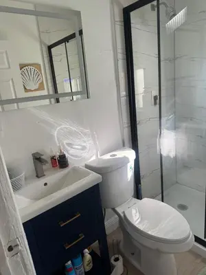 a bathroom with a toilet and a sink and a shower at Charming Historic Home with Modern Comforts in Opa-locka