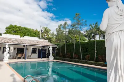 a statue of a woman standing next to a swimming pool at Young Mansion Steps To The Beach in Hollywood
