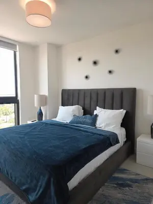 a bedroom with a large bed with a blue blanket at Sweetie Doral studio in Miami
