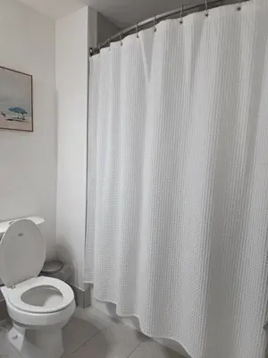 a bathroom with a toilet and a shower curtain at Sweetie Doral studio in Miami