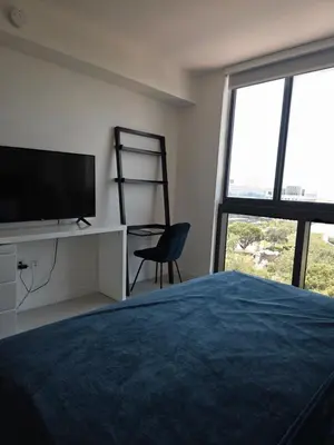 a bedroom with a bed and a tv and a chair at Sweetie Doral studio in Miami