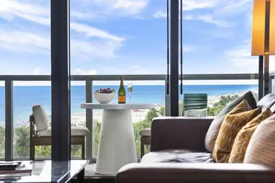 a living room with a couch and a table with a bottle of wine at Oceanview Private Home at South Beach-814 1B in Miami Beach