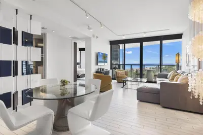 a living room with a glass table and white chairs at Oceanview Private Home at South Beach-814 1B in Miami Beach