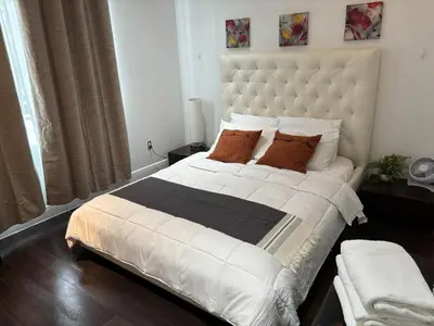 a bedroom with a large white bed with brown pillows at Knickerbocker 102 in Miami Beach