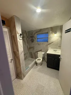 a bathroom with a toilet and a tub and a sink at The Luxe Loft in Fort Lauderdale