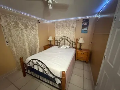 a bedroom with a bed with white sheets and lights at The Luxe Loft in Fort Lauderdale