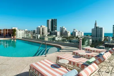 a pool with lounge chairs and a view of a city at UNFRAMED Miami Beach, Autograph Collection in Miami Beach
