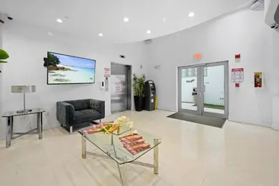 a living room with a chair and a glass table at Spacious APT on South Beach Roof Top Pool & Bar in Miami Beach