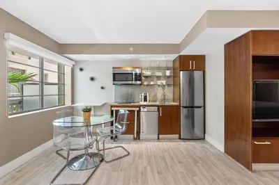a kitchen with a glass table and stainless steel appliances at Modern Studio in the Heart of South Beach in Miami Beach