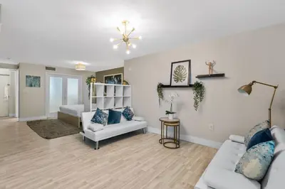 a living room with white furniture and blue pillows at Modern Studio in the Heart of South Beach in Miami Beach