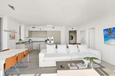 a white living room with a white couch and a kitchen at Luxury Corner Apartment in Hollywood Beach in Hollywood