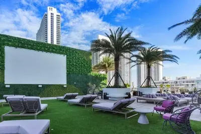 a large outdoor patio with chairs and a blank screen at Luxury Corner Apartment in Hollywood Beach in Hollywood