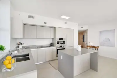 a kitchen with white cabinets and a counter top at Luxury Corner Apartment in Hollywood Beach in Hollywood