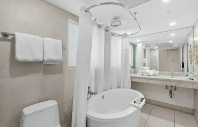 a white bathroom with a toilet and a sink at Heart of South Beach Studio Roof Top Pool Balcony in Miami Beach