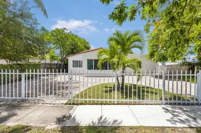 a white fence in front of a white house at Modern 4BR Retreat with Private Pool - Near Brickell in Miami