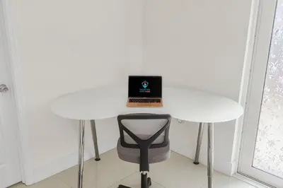 a white table with a laptop on top of it at Modern 4BR Retreat with Private Pool - Near Brickell in Miami