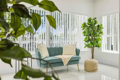 a living room with a blue couch and a plant at Modern 4BR Retreat with Private Pool - Near Brickell in Miami