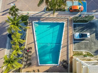 an overhead view of a swimming pool with palm trees at Amazing 1bed on Hollywood Beach Boardwalk W Pool in Hollywood
