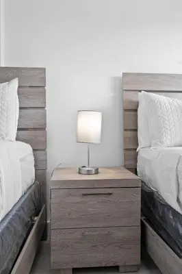 a nightstand with a lamp on it next to two beds at Amazing 1bed on Hollywood Beach Boardwalk W Pool in Hollywood