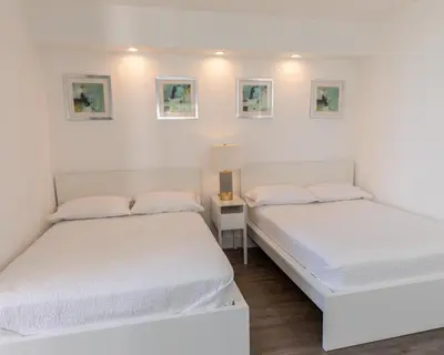 two beds in a room with white walls at The CAROLINE I at King David in Sunny Isles Beach in Sunny Isles Beach