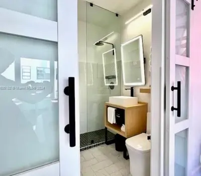 a bathroom with a toilet and a sink and a shower at Tropical South Beach Condo - Pool & Miami Beach Vibes in Miami Beach