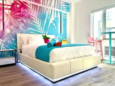 a bedroom with a bed with a tropical wall at Tropical South Beach Condo - Pool & Miami Beach Vibes in Miami Beach