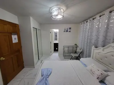 a bedroom with a bed and a door and a chair at Paseo Miami in Miami