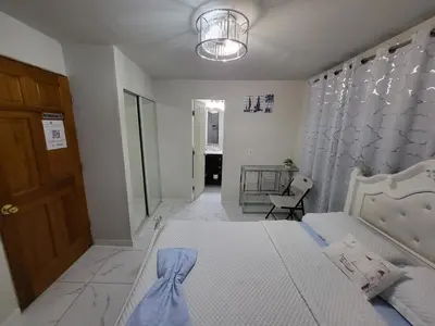a bedroom with a bed and a door and a chair at Paseo Miami in Miami