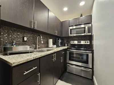 a kitchen with stainless steel appliances and wooden cabinets at Nice 2 bedrooms near the beach in Miami Beach