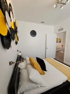 a bedroom with a bed with yellow and black pillows at Nice 2 bedrooms near the beach in Miami Beach