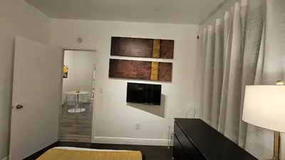 a living room with a television and a room with a bed at Nice 2 bedrooms near the beach in Miami Beach