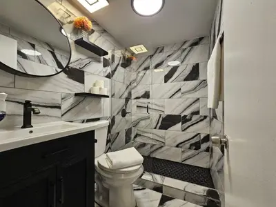 a bathroom with a sink and a toilet and a mirror at Nice 2 bedrooms near the beach in Miami Beach