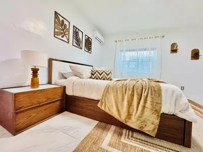 a bedroom with a large bed and a window at Earth-Toned Escape, Stylish Stay in Miami