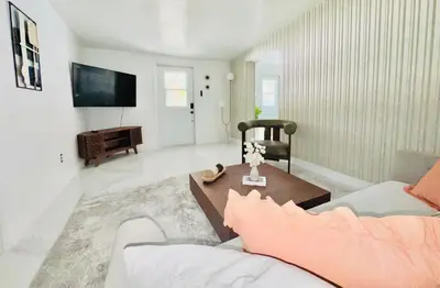 a living room with a couch and a table at Earth-Toned Escape, Stylish Stay in Miami