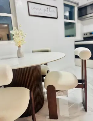 a table with chairs and a vase of flowers on it at Earth-Toned Escape, Stylish Stay in Miami
