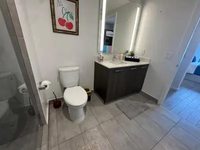 a bathroom with a toilet and a sink and a mirror at Spectacular corner 2BDR Downtown Miami in Miami
