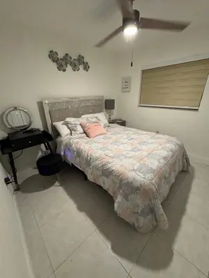 a bedroom with a large bed with pink pillows at 4bdrm Waterfront salt water Pool home with Outdoor theater Game Rm Make up vanities in every room Perfect for Game days and concerts trips to Miami Hard rock stadium and hotel 15 mins away in Miramar