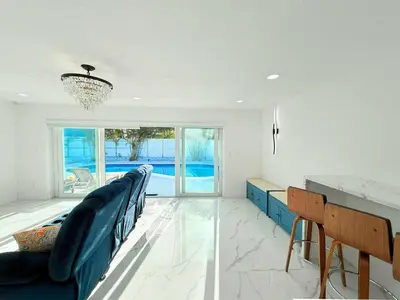 a living room with blue chairs and a table at Ultimate Getaway Private Pool & Games Near Beach in Fort Lauderdale