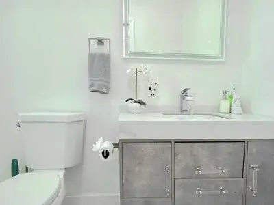 a bathroom with a toilet and a sink and a mirror at Ultimate Getaway Private Pool & Games Near Beach in Fort Lauderdale