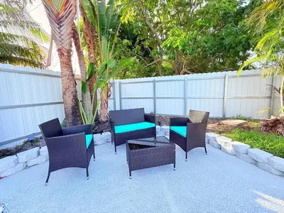 a patio with chairs and a table and a fence at Ultimate Getaway Private Pool & Games Near Beach in Fort Lauderdale