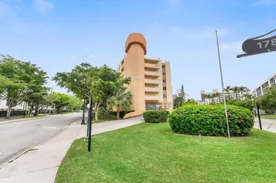 a street sign in the grass in front of a building at 2BR-2BA with Pool Gym Beach Marbella Tower in Sunny Isles Beach