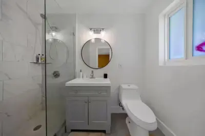a white bathroom with a sink and a mirror at Hidden Miami Oasis Heated Pool and Games in Golden Glades